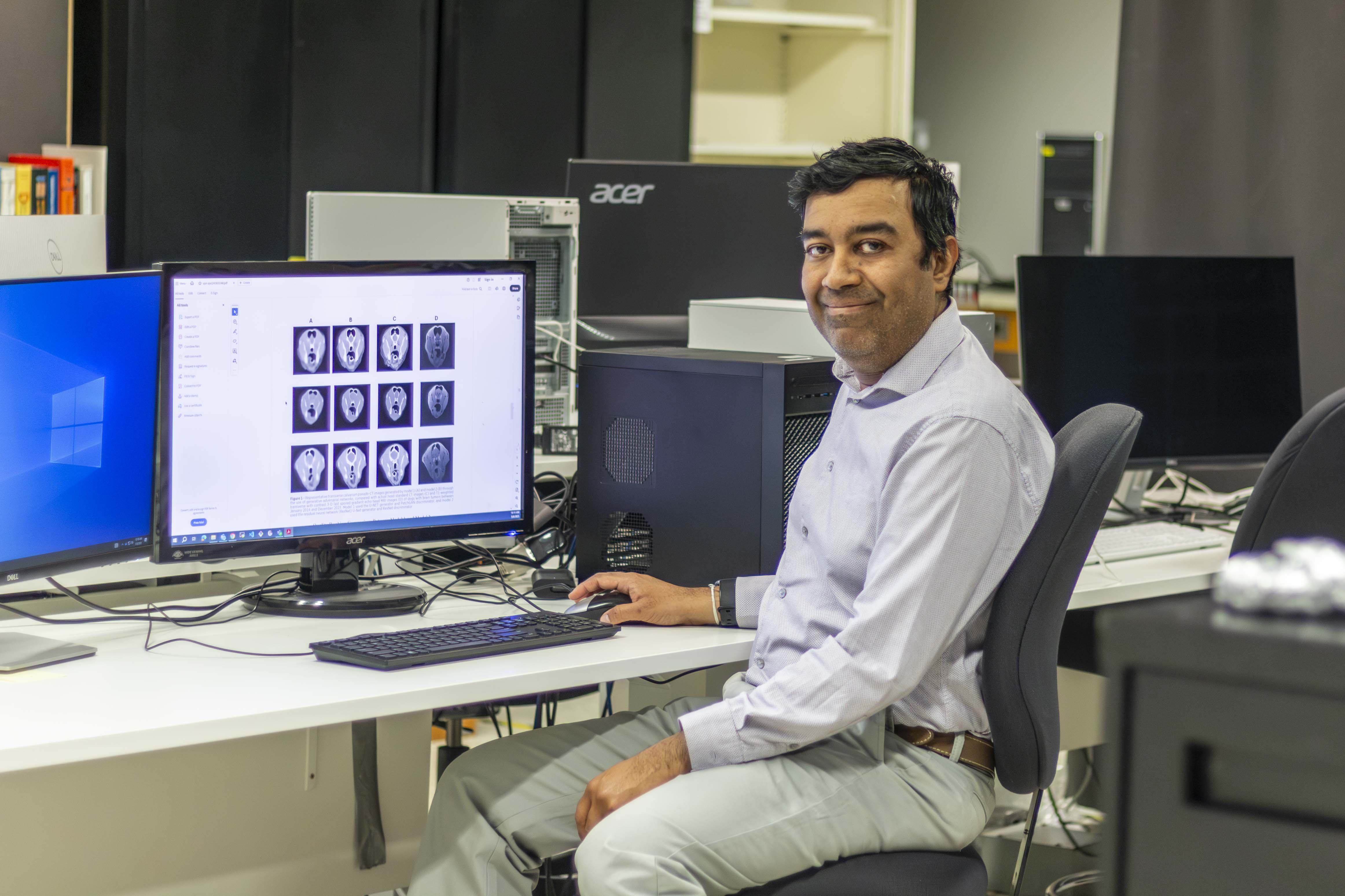 Dr. Eranga Ukwatta in lab with scans from research paper at the University of Guelph