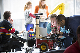 Image of students looking at robot