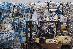 Image of large amount of plastic waste with forklift in front