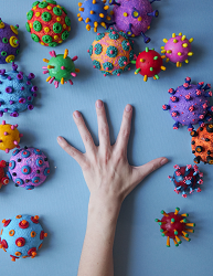 A graphic showing  a hand amongst a number of coronavirus variants