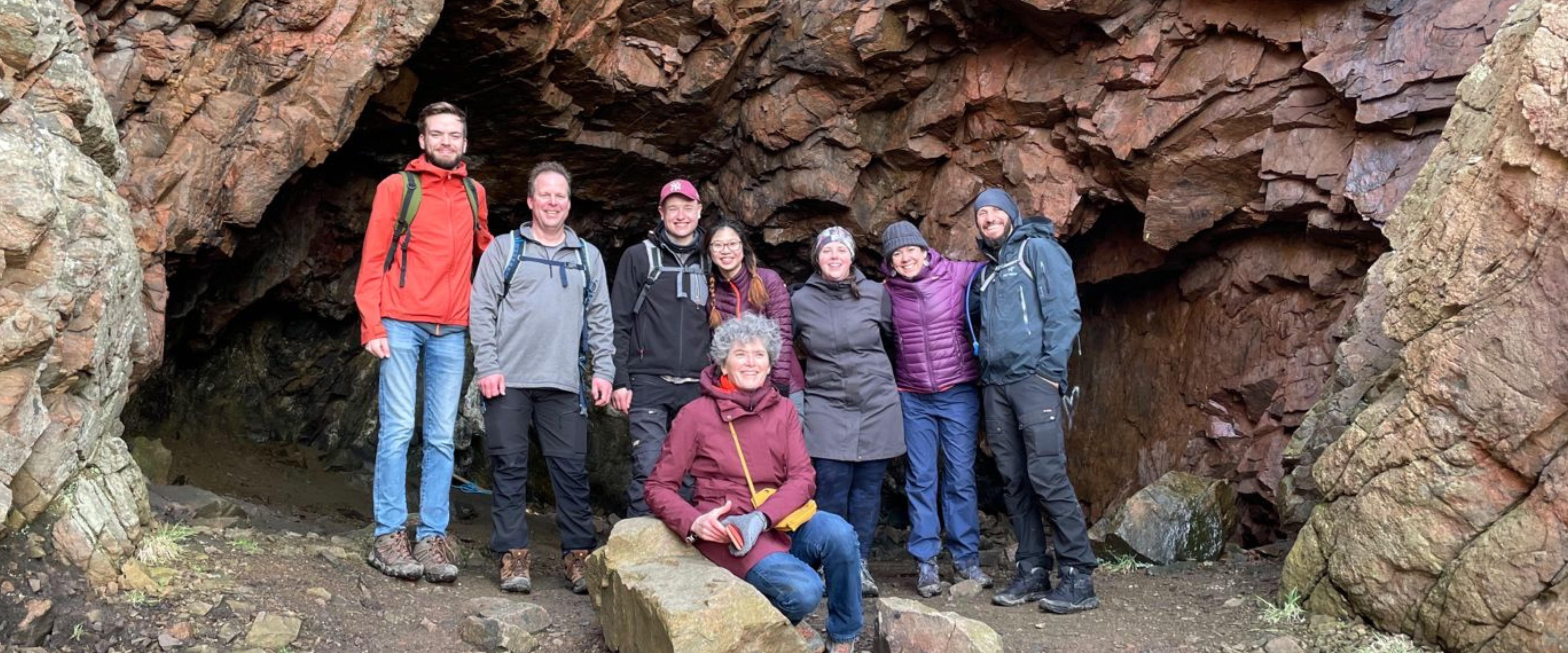 Image of group of researchers under large rock formation.