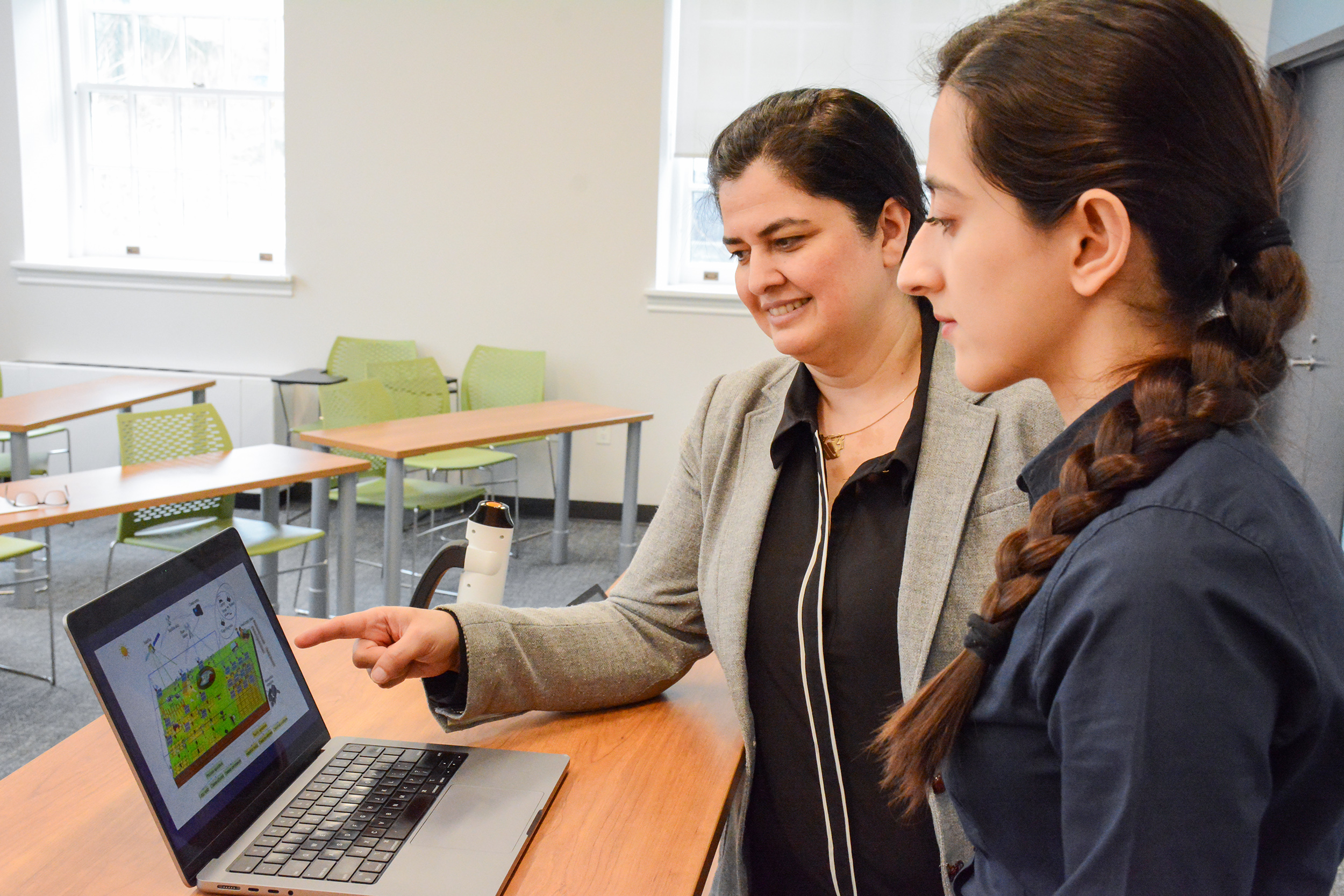Dr Rozita Dara, left, showing a student content on a laptop in a classroom.